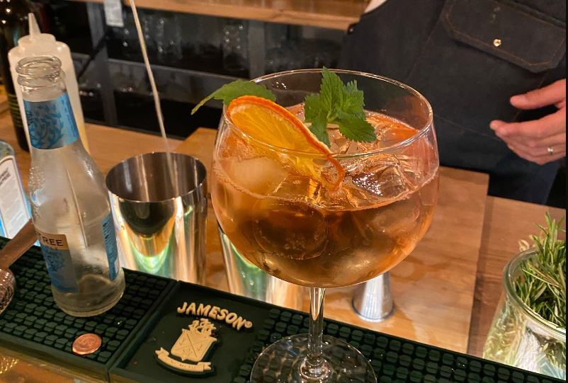 Verre avec des agrumes et de la menthe, servi au comptoir du bar Les Frangins aux Eaux-Vives